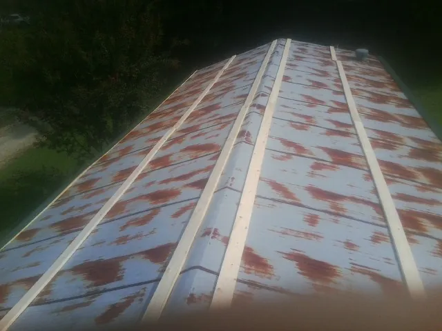 Rusted metal roof panels with new wood purlins before replacement — Storm Damage Roof Repair in Nye by Roofing Brothers