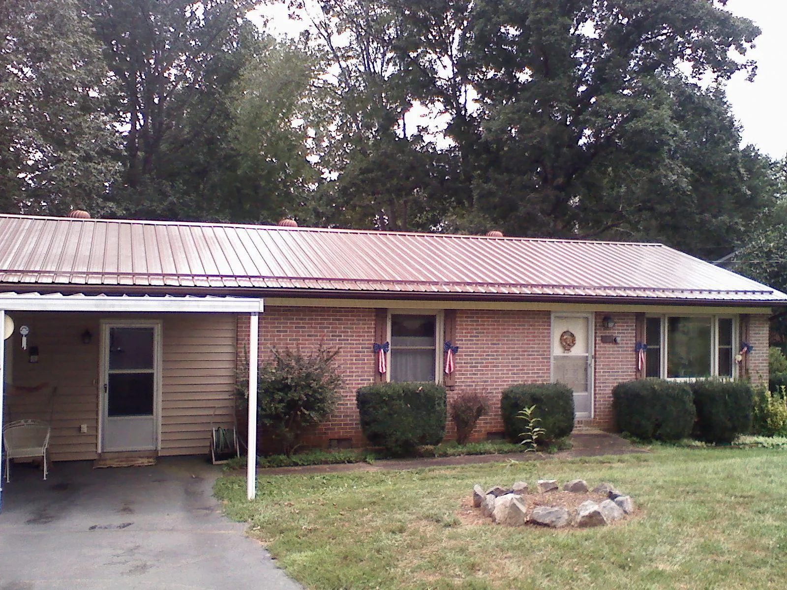 Bronze metal roof and carport on a brick ranch home — Roof Repair work by our crew in Nye